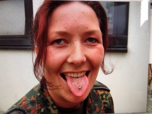 Junge Bundeswehrsoldatin in Flecktarnuniform lächelt in die Kamera – frühe Dienstjahre, persönlicher Karrierebeginn