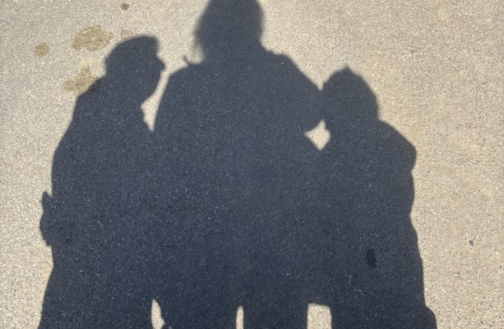 Schatten von Mutter und zwei Kindern auf einem Weg – erstes Jahr zu dritt nach der Trennung