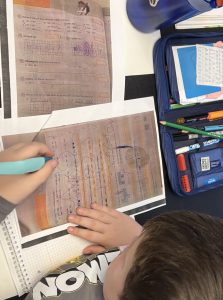 Kind malt auf Lernblatt zur Vorbereitung auf die Mathearbeit in der Grundschule