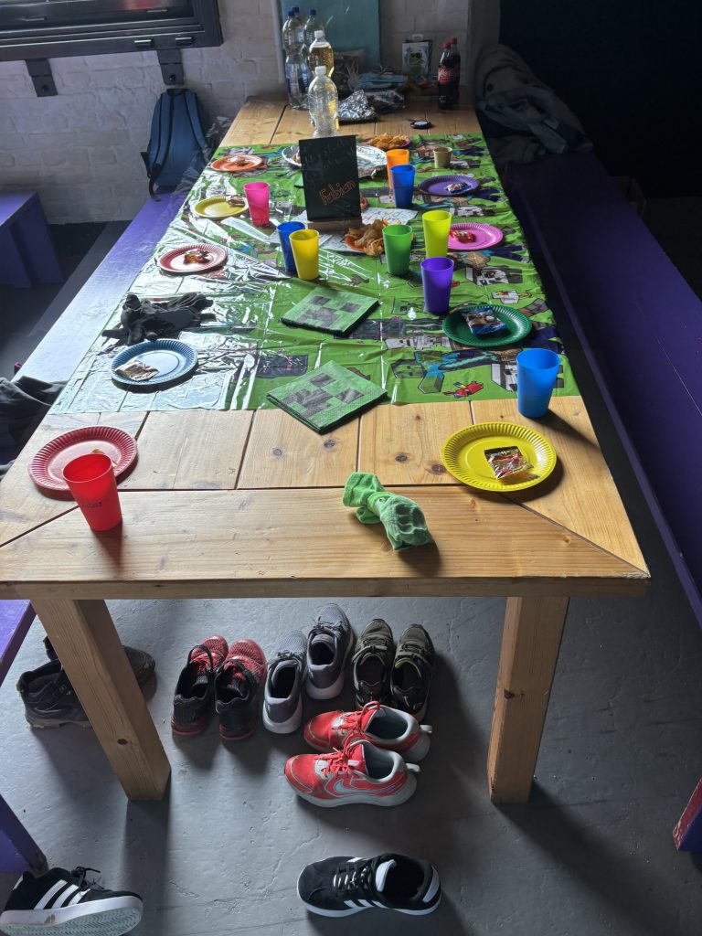 Alltag als Mutter während einer Kindergeburtstag mit buntem Partytisch