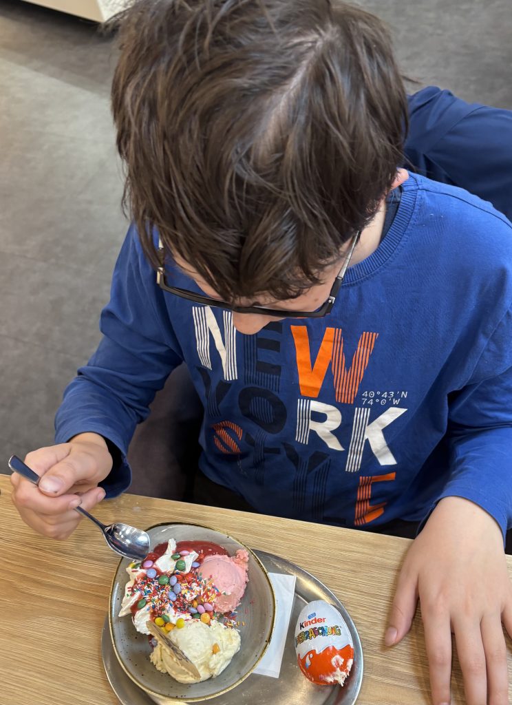 Alltag Soldatin Mama Kinder essen Eisbecher in der Eisdiele während der Osterferien