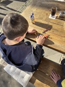 Kinder sitzen beim Essen und spielen mit Dinosauriern nach der DinoXperience Königswinter