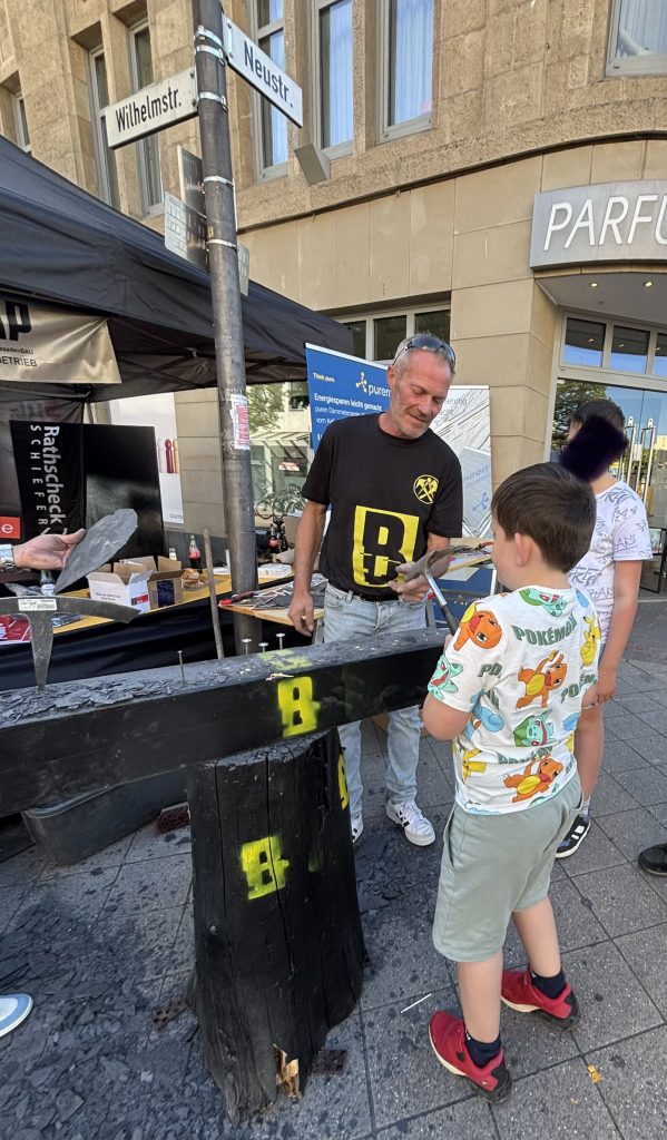 Kind schlägt Nägel in einen Tisch beim Stadtfest Euskirchen