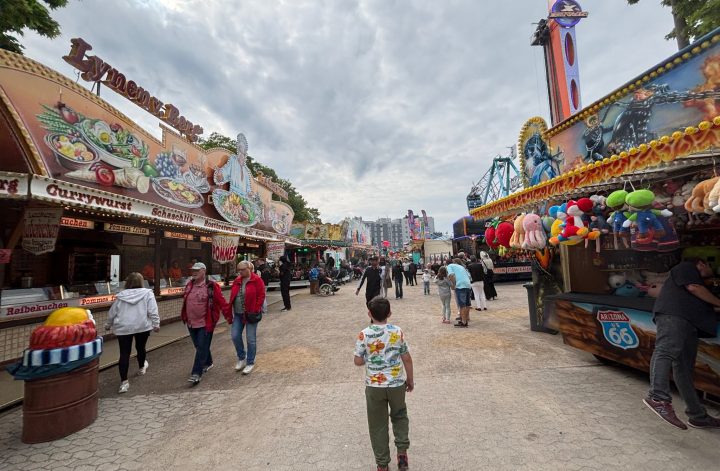 Kind läuft über die Donatus Maikirmes Euskirchen zwischen Fahrgeschäften und Buden