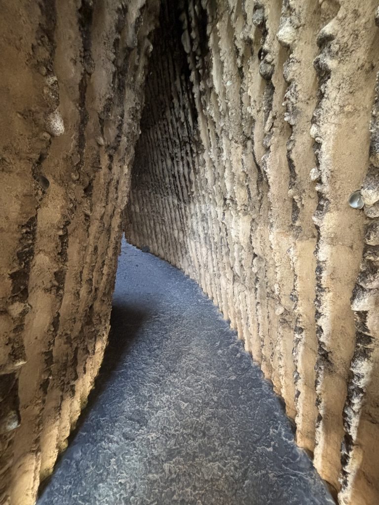 Innenraum der Bruder Klaus Kapelle mit rauen Wänden und schmalem Gang