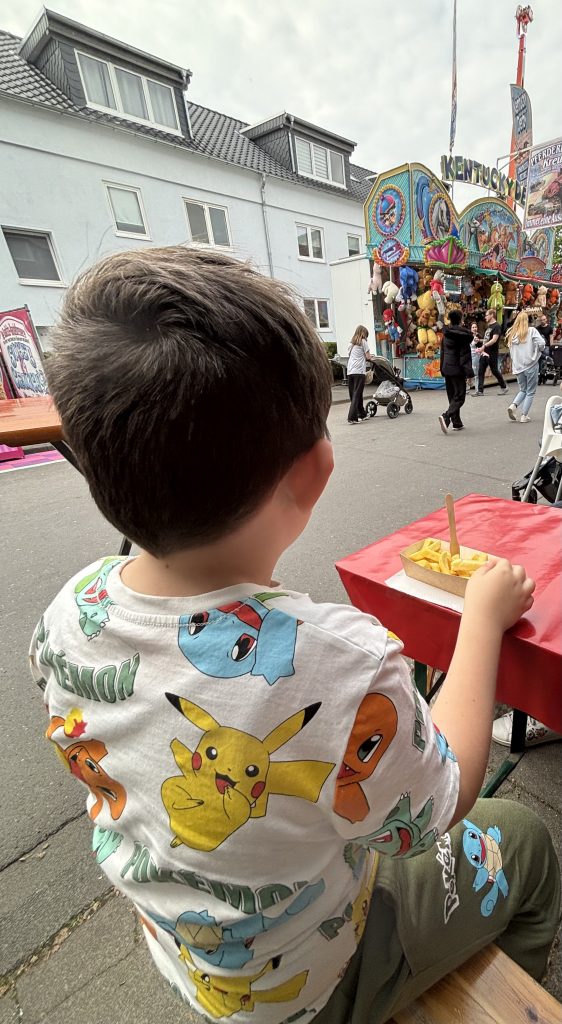 Kind isst Pommes auf der Donatus Maikirmes Euskirchen